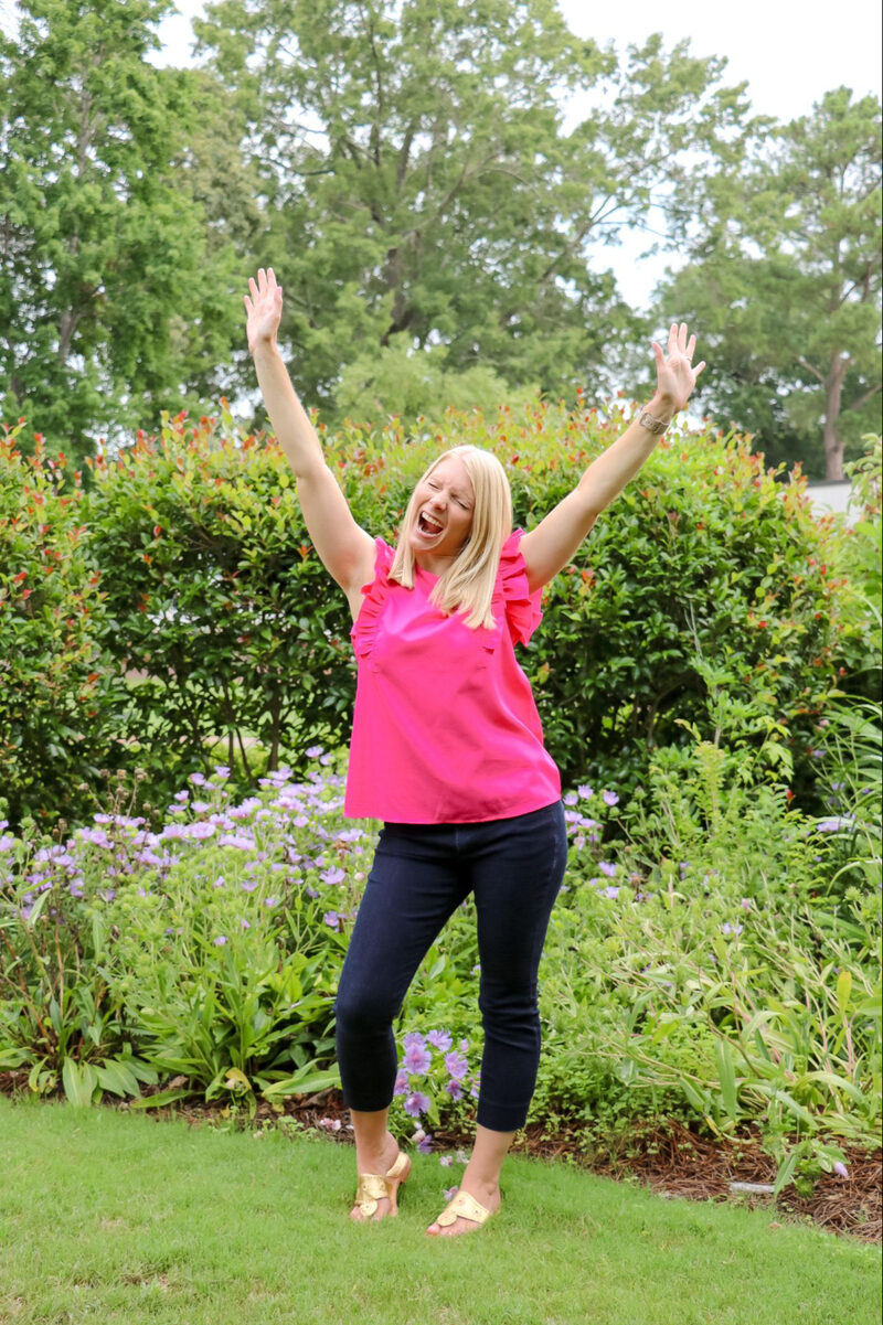 Kayla celebrating outdoors in a pink top